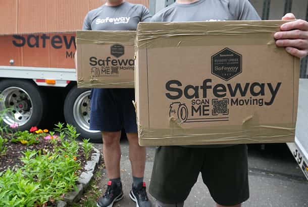 Two Safeway movers carrying branded cartons