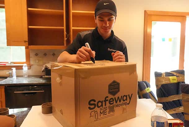 Safeway crew member labelling a packed carton in a kitchen